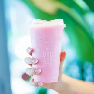 a hand holding a pink drink