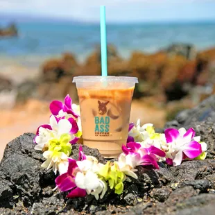 a cup of iced coffee on a rock