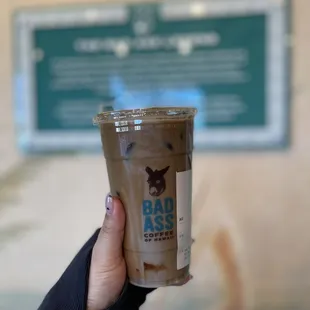 a hand holding a cup of iced coffee