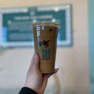 a hand holding a cup of iced coffee