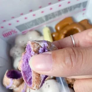 a hand holding a half eaten doughnut