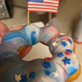 a hand holding a decorated donut