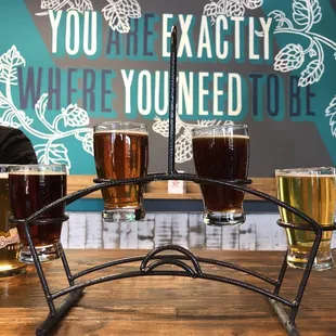 a man sitting at a table with four glasses of beer