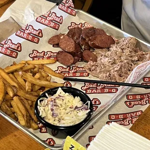 ows a tray of pulled pork, fries, coleslaw, coleslaw