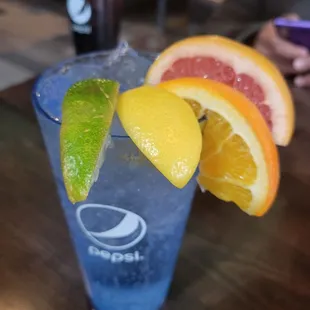 a blue cocktail with oranges and limes