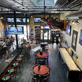 the inside of a bar with tables and chairs