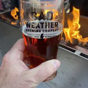 a hand holding a glass of beer