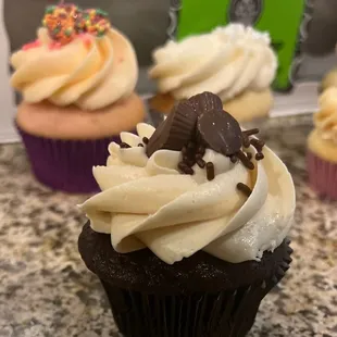 chocolate cupcakes with white frosting and sprinkles