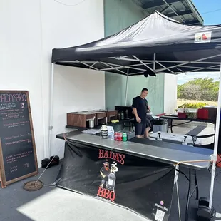 a man preparing food under a tent