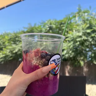 a hand holding a cup of smoothie