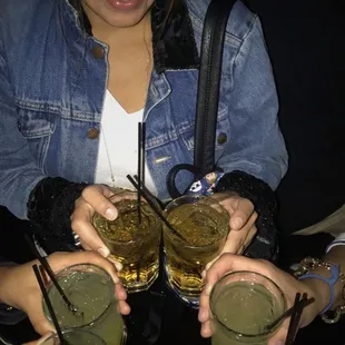 two women holding glasses of drinks