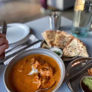 a bowl of soup and a plate of naan bread