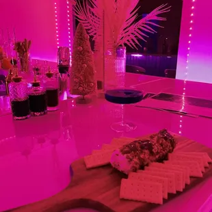 a cheese board with crackers and a glass of wine