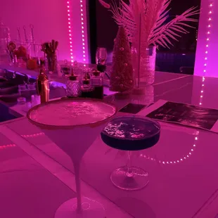 two cocktail glasses on a bar counter
