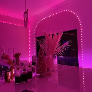 a bar with pink lights and decorations