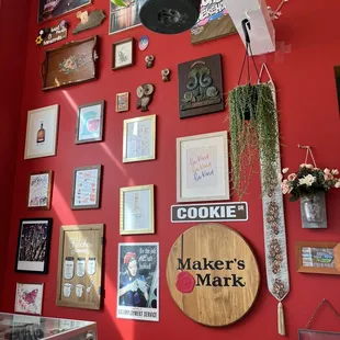 a red wall with a variety of framed pictures