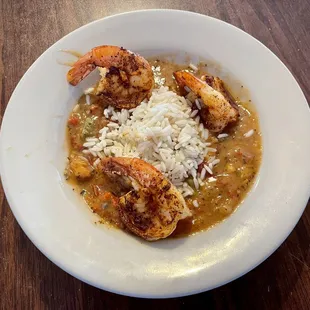 Bowl of gumbo topped with blackened shrimp