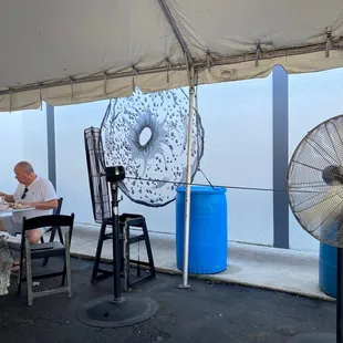 a man sitting at a table under a tent