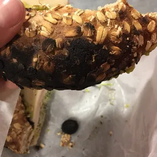 a hand holding a half eaten bagel