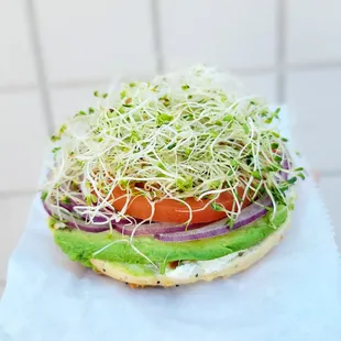 Mania Bagel with garlic cream cheese, avocado, red onion, tomatoes and sprouts