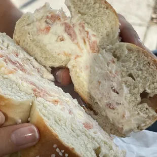 a person holding a sandwich with a bite taken out of it