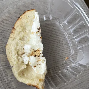 a half eaten bagel in a plastic container