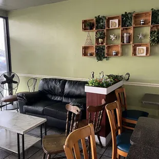 Cute inside seating area with tables chairs and a loveseat