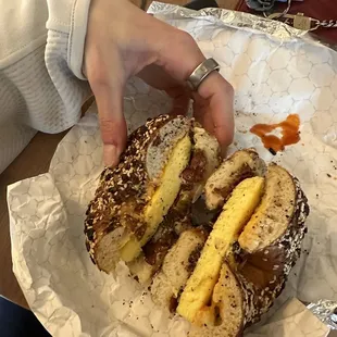 a person grabbing a bagel with bananas