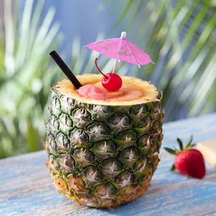 Ultimate Pineapple – With spiced rum, Coco López &amp; Bacardi Black Rum swirled with strawberry ice and served in a freshly cut pineapple