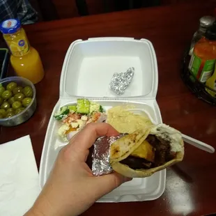 Beef lamb shawarma with tzatziki sauce. Sides are babaganoush and feta veggie salad.