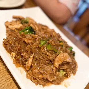 a plate of noodles with chicken and broccoli