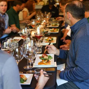 a group of people sitting at a table with wine glasses