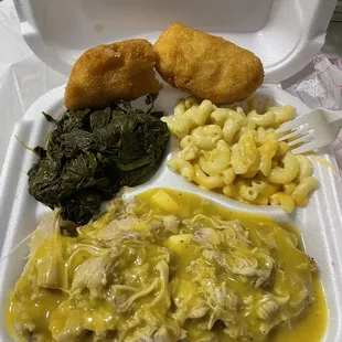 Chicken and dressing with gravy, turnip greens, macaroni and cheese, and hushpuppies