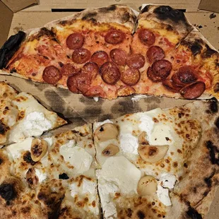 Half of a pepperoni pizza and half of a Bianca "white" pizza.