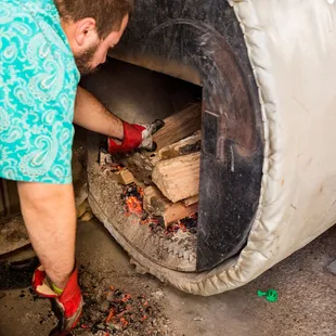 a man putting wood into an oven