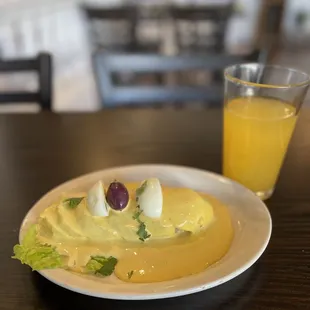 a plate of food and a glass of orange juice