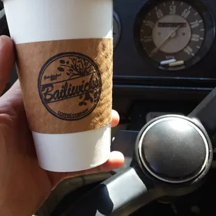 a hand holding a coffee cup