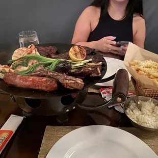 a woman sitting at a table with food