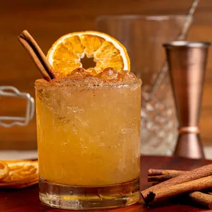 a cocktail with orange slices and cinnamon