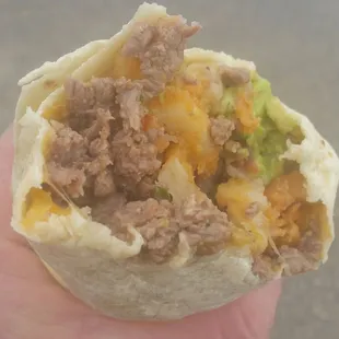 a hand holding a burrito