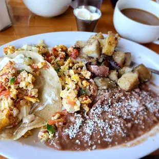 a plate of mexican food and a cup of coffee