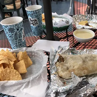 Clockwise from 12: 3 tacos, queso dip, brisket burrito, chips