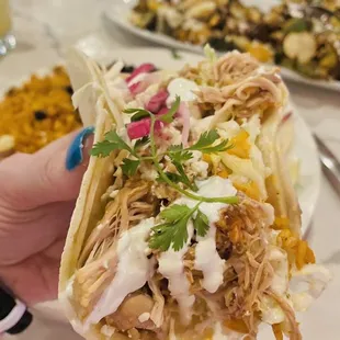 a person holding up a taco