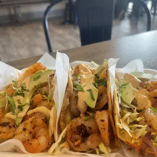 a plate of tacos with shrimp and lettuce