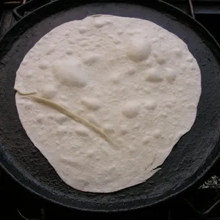 Fresh hand stretched raw flour tortilla hitting the griddle for the first time before becoming a &apos;Baja Style&apos; Burrito Grande!