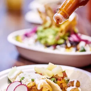 a plate of tacos and a bottle of beer