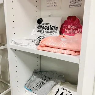 a shelf with t - shirts on it
