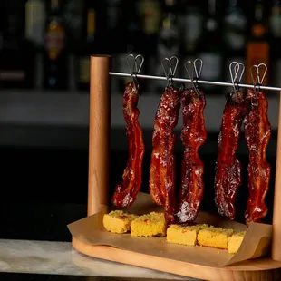 Hang&apos;N Bacon
 
 Hanging bacon over cornbread with a choice of mango habanero glaze or maple syrup.