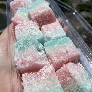 a hand holding a container of marshmallows