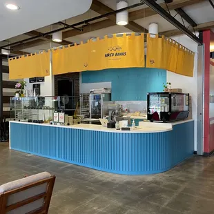 We're at the front entrance at 4th Street Market food hall! Yellow curtains above, blue painted cabinets below.